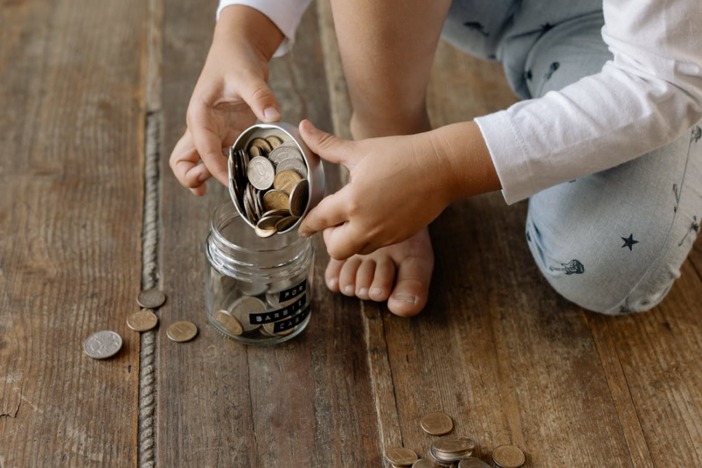 money scripts from childhood represented by a child saving coins in jar