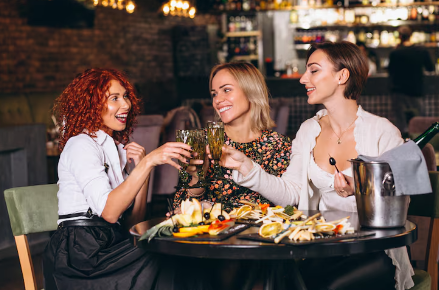 Friends dining at upscale restaurant illustrating social comparison and spending pressure.
