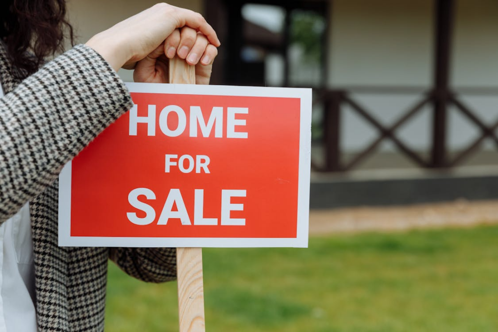 Home for sale sign representing deciding when to sell an investment property.
